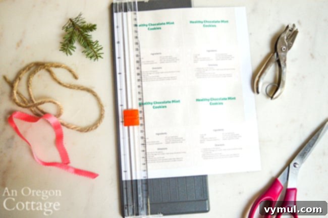 Cutting out free printable 'Merry & Bright' recipe tags for chocolate mint cookie mason jar gifts.
