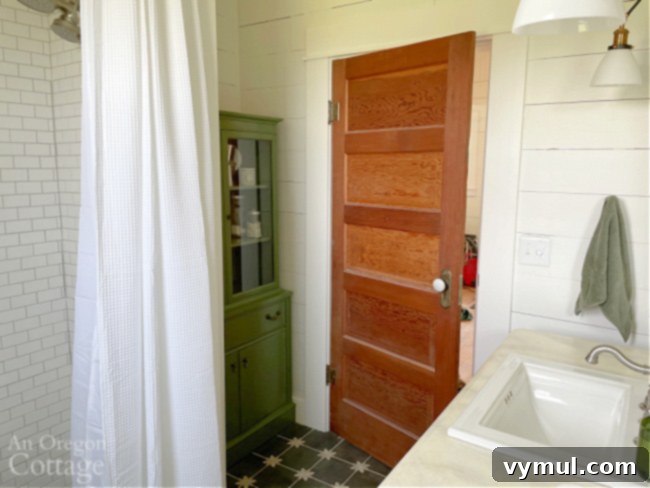 Farmhouse Moving Day: Vintage Finds, Cozy Linens, and Literary Treasures 6 finished farmhouse bathroom with vintage green cabinet, wood door, original shiplap, and subway tile shower
