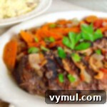 Rustic Italian Slow Cooker Pot Roast 5 beef roast on white platter with carrots