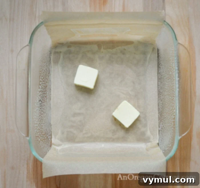 Flourless Chewy Noels Bars A Fresh Take on Christmas Cookie Classics 5 Prepped baking pan with melted butter for noel cookies.