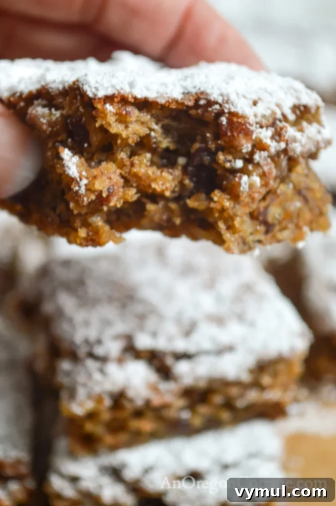 Flourless Chewy Noels Bars A Fresh Take on Christmas Cookie Classics 8 A hand reaching for a flourless chewy noels bar cookie, highlighting its deliciousness.