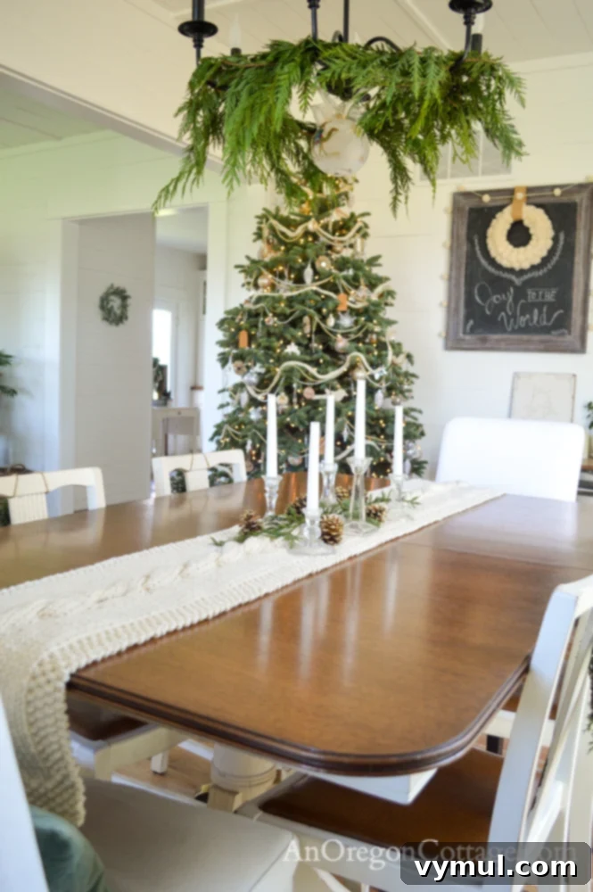 White and green farmhouse Christmas dining table with hand-knitted cabled table runner and chandelier