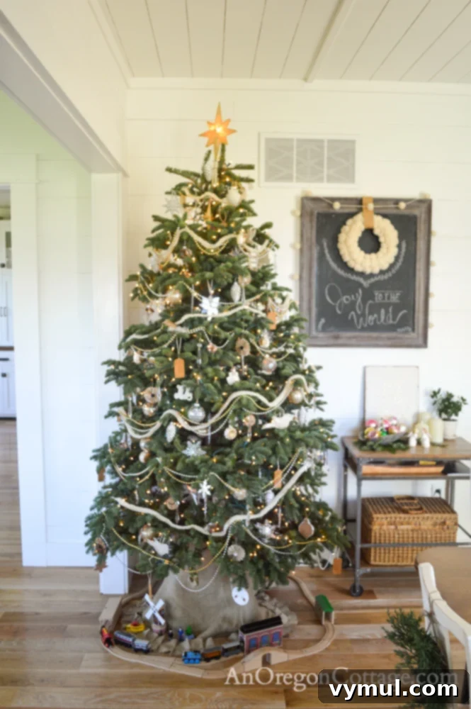 Real Noble Fir Christmas tree with handmade, vintage, and store-bought decorations in farmhouse dining room