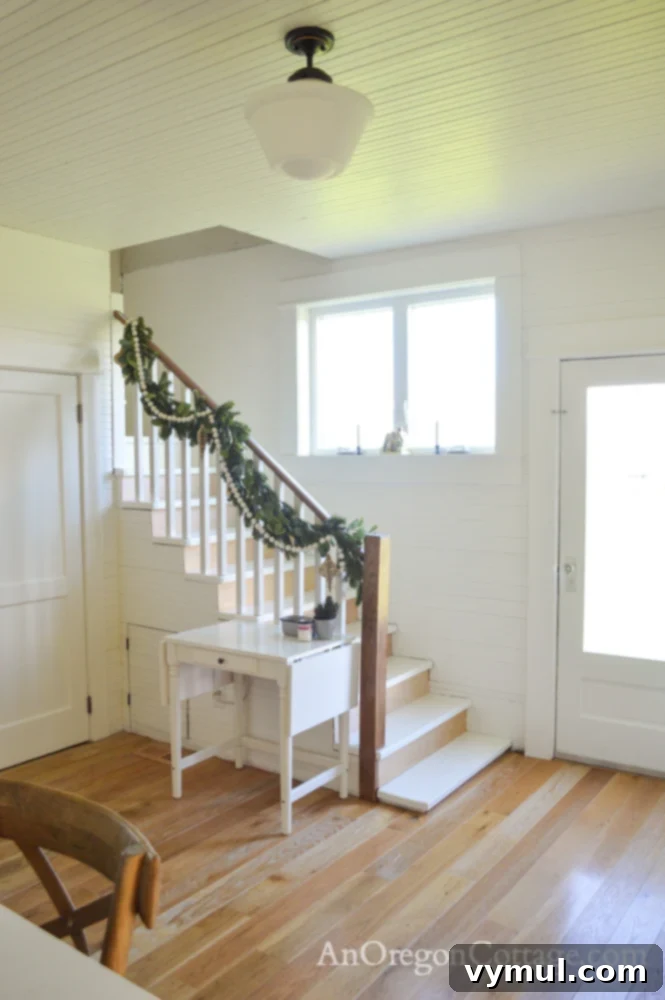 Farmhouse Christmas garland on a stair rail with handmade ornaments