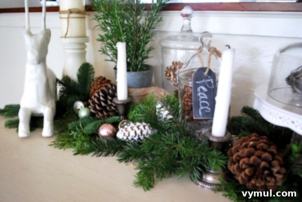 Elegantly styled Christmas sideboard vignette featuring the DIY white deer, fresh rosemary, pinecones, and vintage ornaments