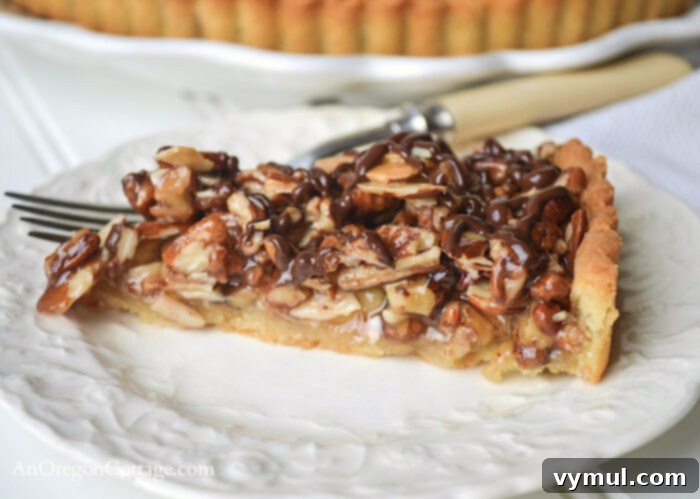 Easy Honey Caramel Triple Nut Tart 9 A close-up shot of a single slice of Honey Caramel Triple Nut Tart, revealing the layers of nuts and caramel.
