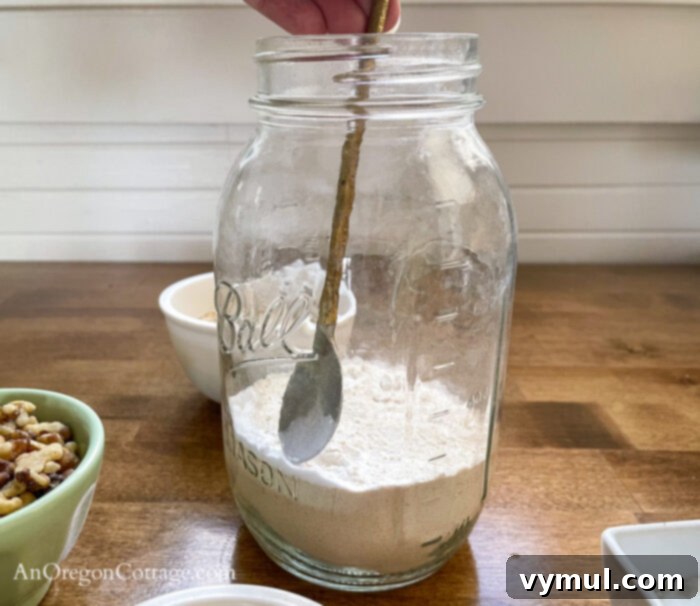 DIY Cranberry White Chocolate Cookie Mix Jar Gift 5 Spreading baking soda with a spoon to create distinct layers in cookie mix jar