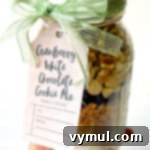 holding cranberry white chocolate cookie mix in a jar