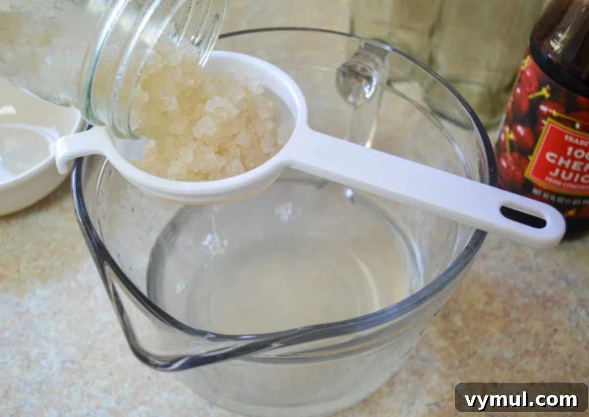 Homemade Water Kefir Made Easy 9 Straining water kefir grains from the first ferment into a glass measuring cup