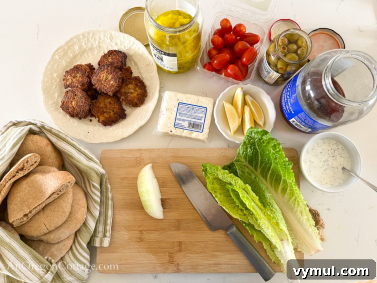 Selection of fresh ingredients for a tuna patty pita board including tuna patties, pita, vegetables, and feta cheese.