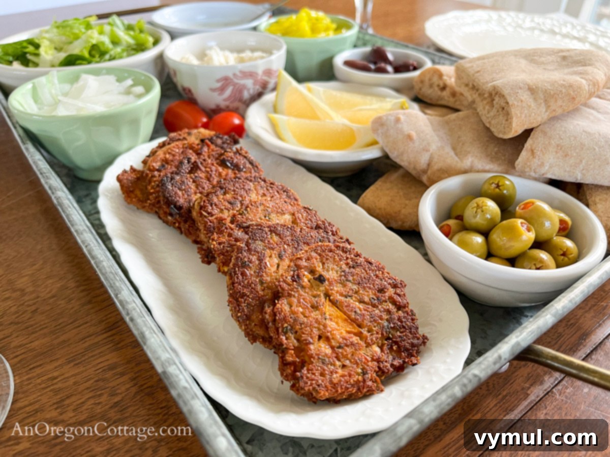 Side view of a Mediterranean tuna patty pita platter with warm patties and fresh toppings.