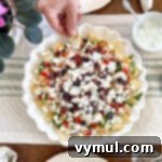 15-Minute No-Bake Greek Nachos 11 Eating nachos from platter