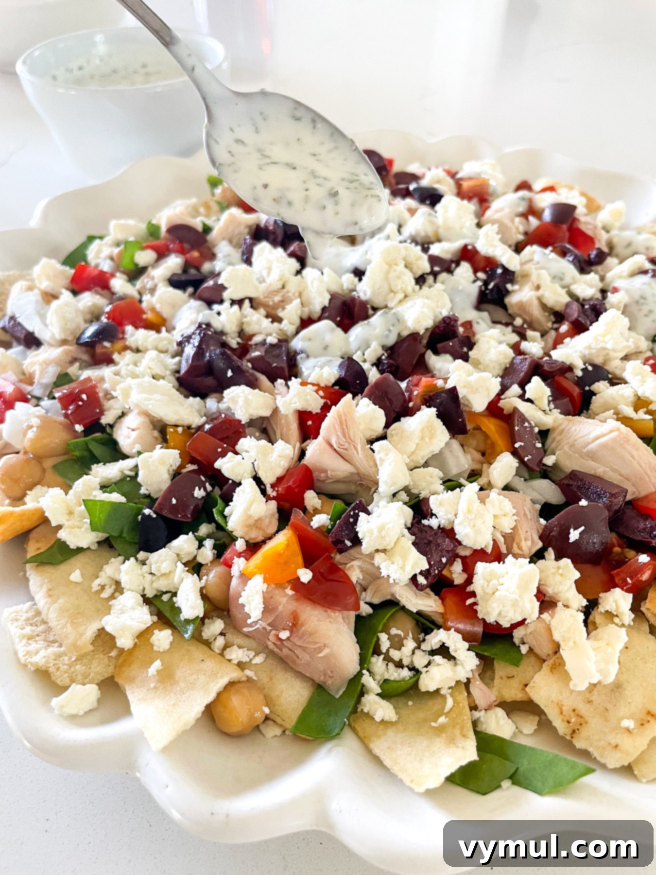 15-Minute No-Bake Greek Nachos 8 spooning sauce onto layers of nachos