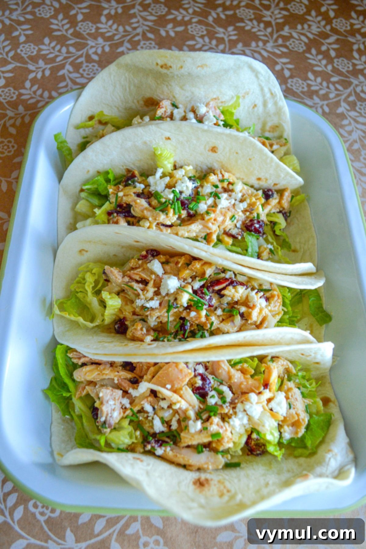 18 Foolproof Chicken Salad Recipes for Any Meal or Gathering 3 Delicious cranberry feta chicken salad served in tortillas, stacked enticingly in a pan.