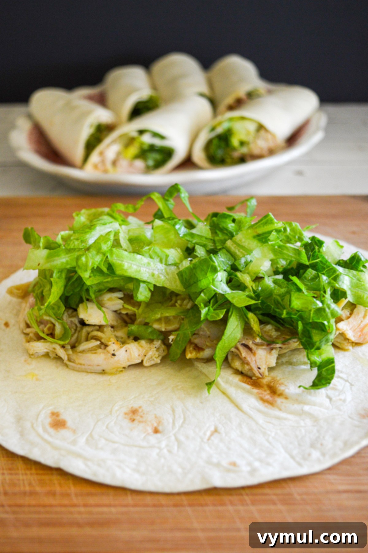 18 Foolproof Chicken Salad Recipes for Any Meal or Gathering 4 Classic Caesar chicken salad topped with crisp lettuce on an open tortilla, ready to be wrapped.