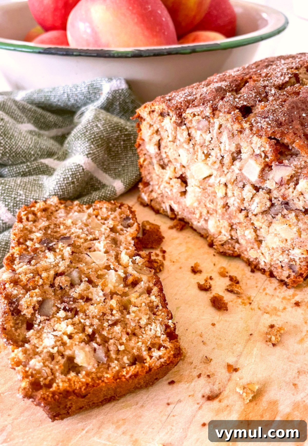 Easy Wholesome Honey Cinnamon Apple Oat Loaf 8 Warm, sliced loaf of apple bread on a cutting board next to fresh apples