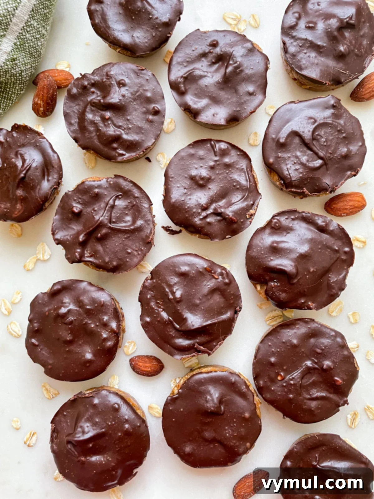 A top-down view of finished no-bake chocolate almond oat cups neatly arranged on a white counter, showcasing their perfect chocolate tops.