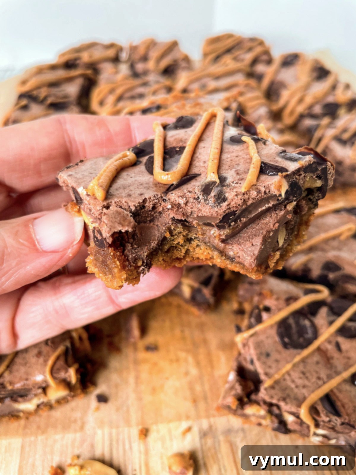 No-Bake Gluten-Free Chocolate Peanut Butter Magic Bars 11 holding a cookie bar