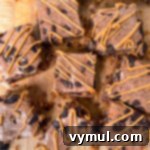 No-Bake Gluten-Free Chocolate Peanut Butter Magic Bars 12 A stacked image of freshly baked chocolate peanut butter bars, drizzled with extra peanut butter.