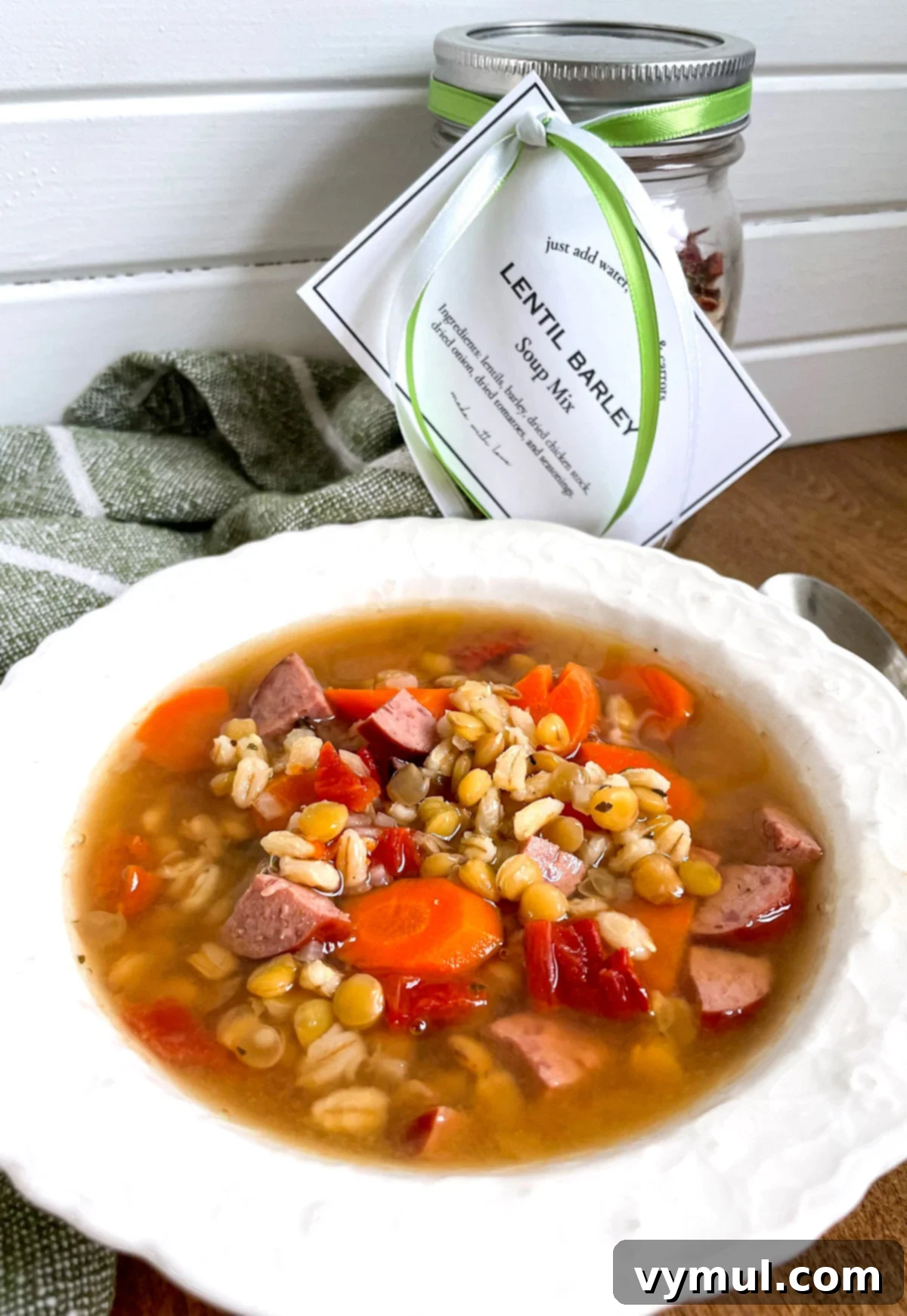 Effortless Homemade Lentil Barley Soup Mix 7 A cozy bowl of lentil barley soup in the foreground, with a beautifully layered jar of the dry mix blurred in the background, symbolizing the journey from mix to meal.