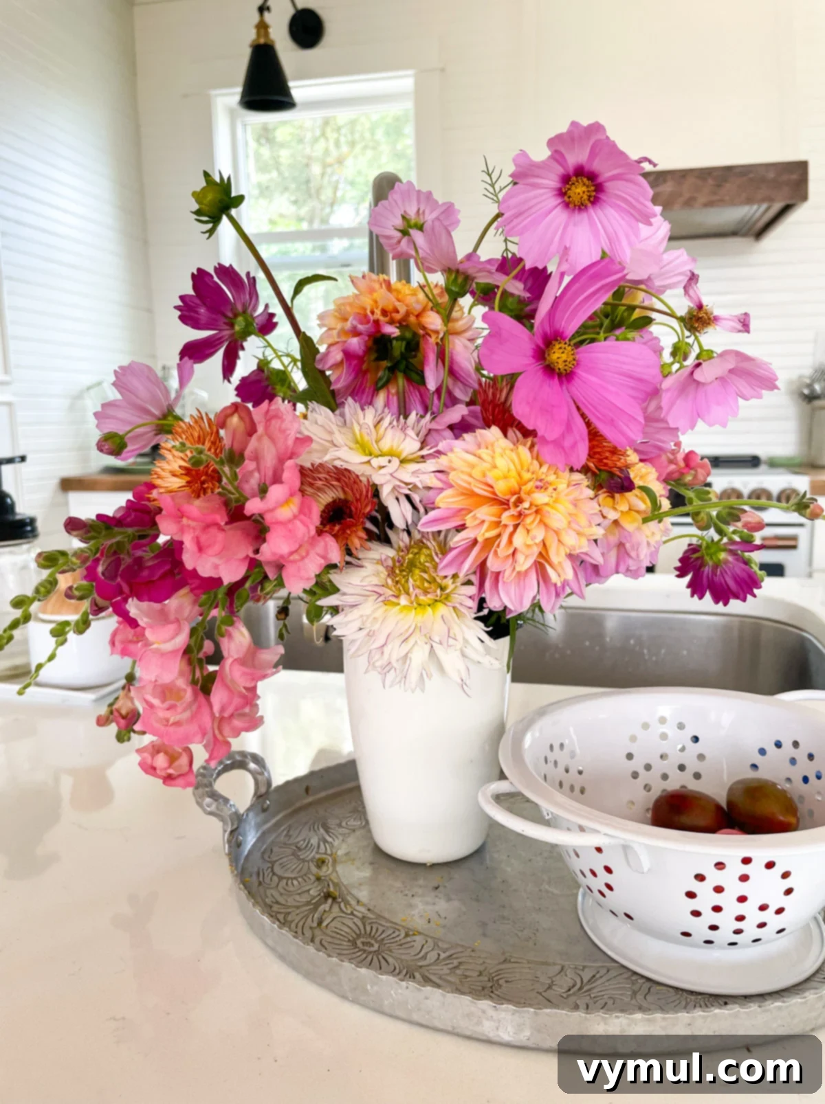 A vase of cut flowers in a white kitchen.