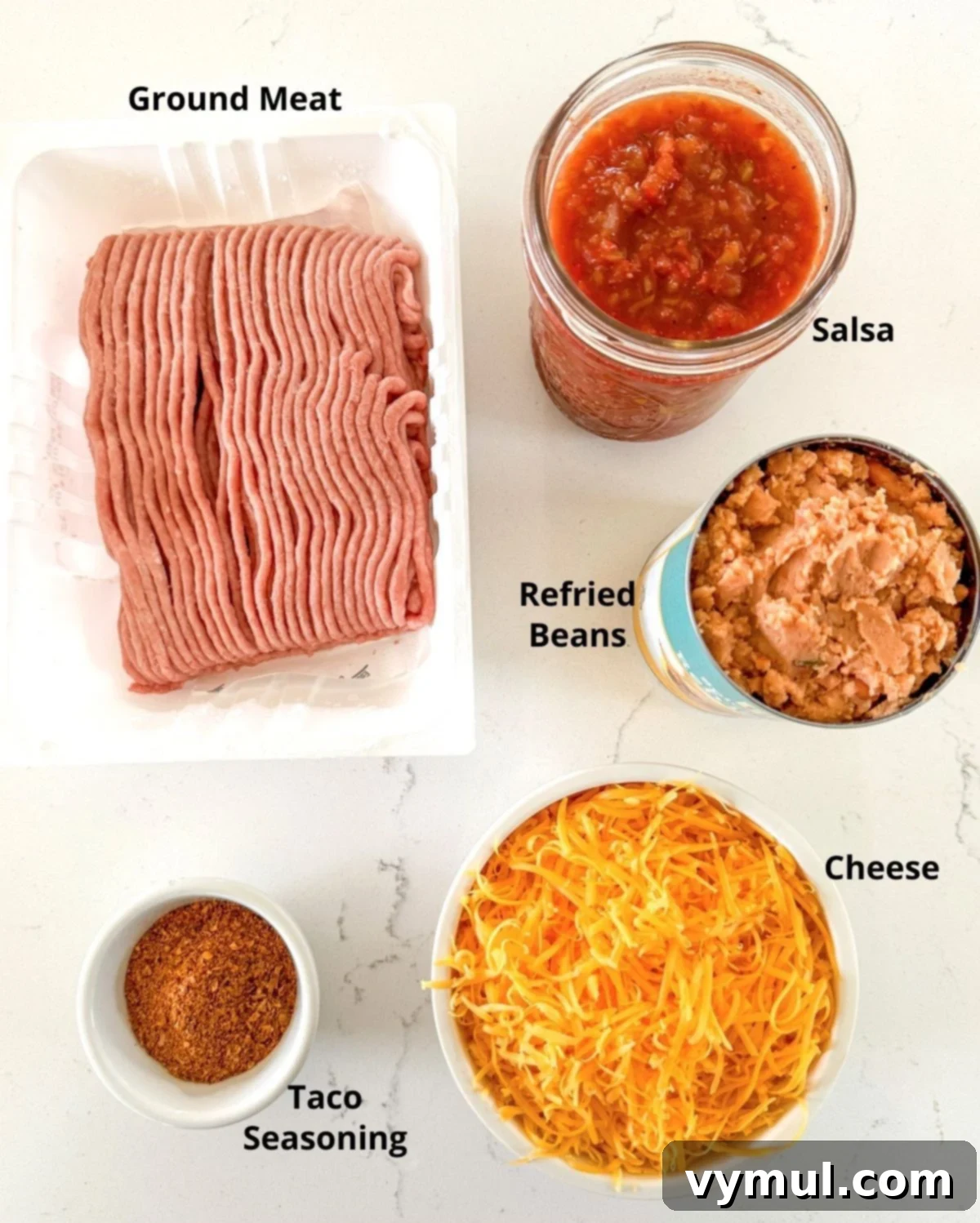 Hands-Off 5-Ingredient Taco Dip for Slow Cooker and Instant Pot 3 A flat lay photograph showcasing the five simple ingredients required for the slow cooker taco dip: ground meat, cheese, refried beans, salsa, and taco seasoning.
