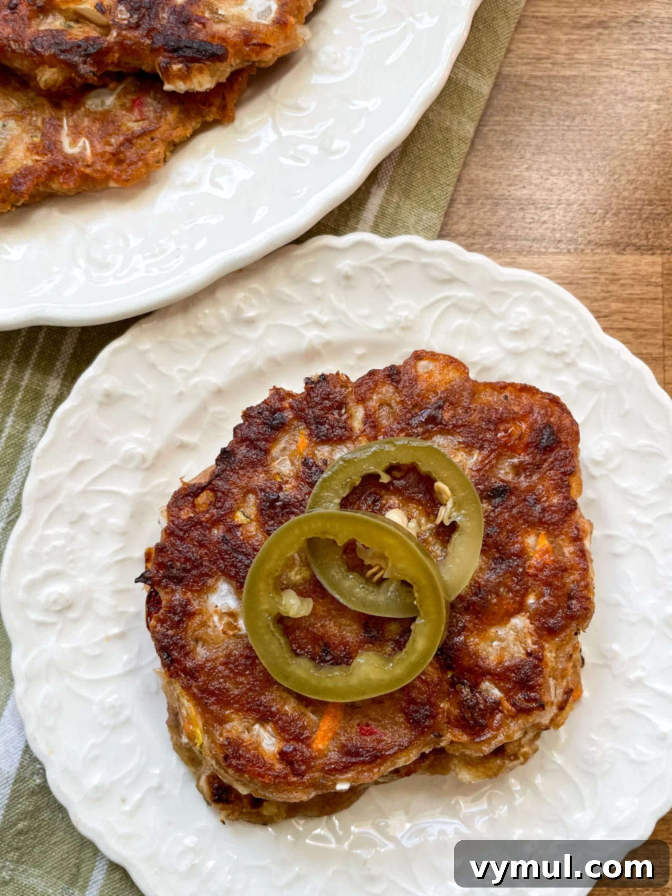 35 Clever Ways to Use Sourdough Discard 3 vegetable sourdough fritters on a white plate with pickled peppers