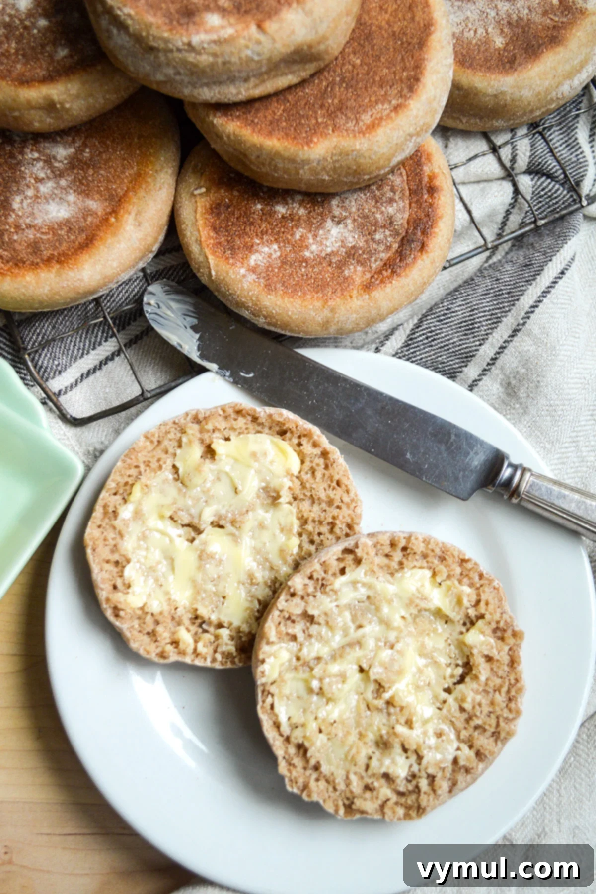35 Clever Ways to Use Sourdough Discard 4 cut english muffin on a white plate with butter