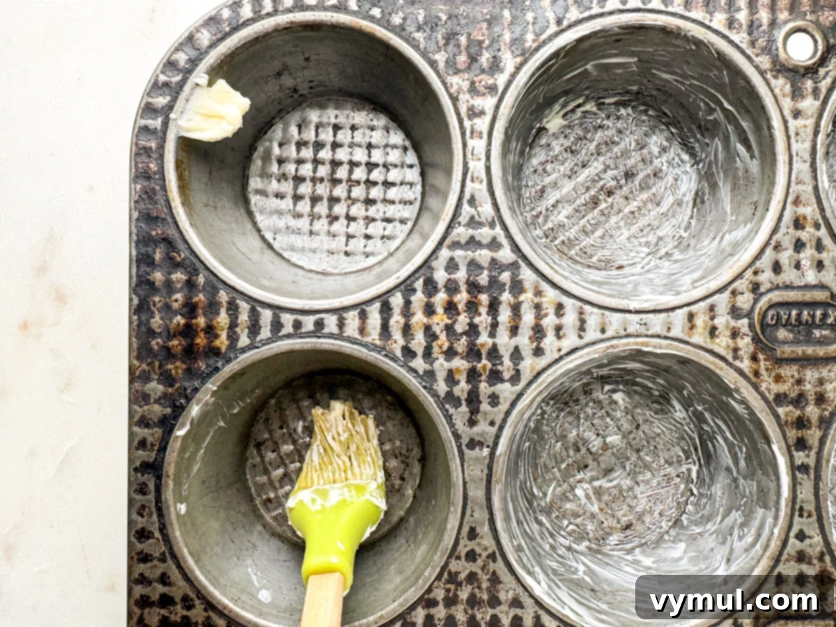 buttering muffin tin with silicone brush