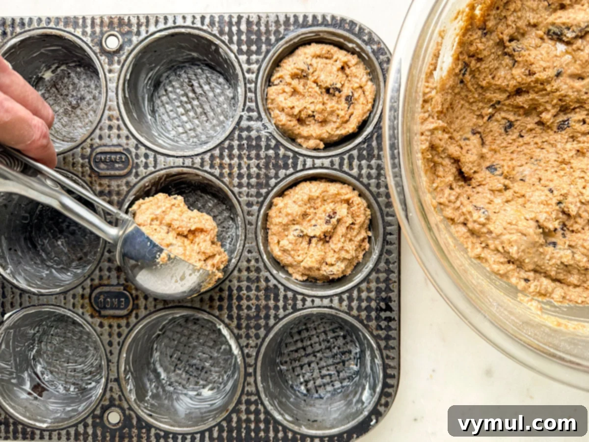 scooping batter into muffin tin