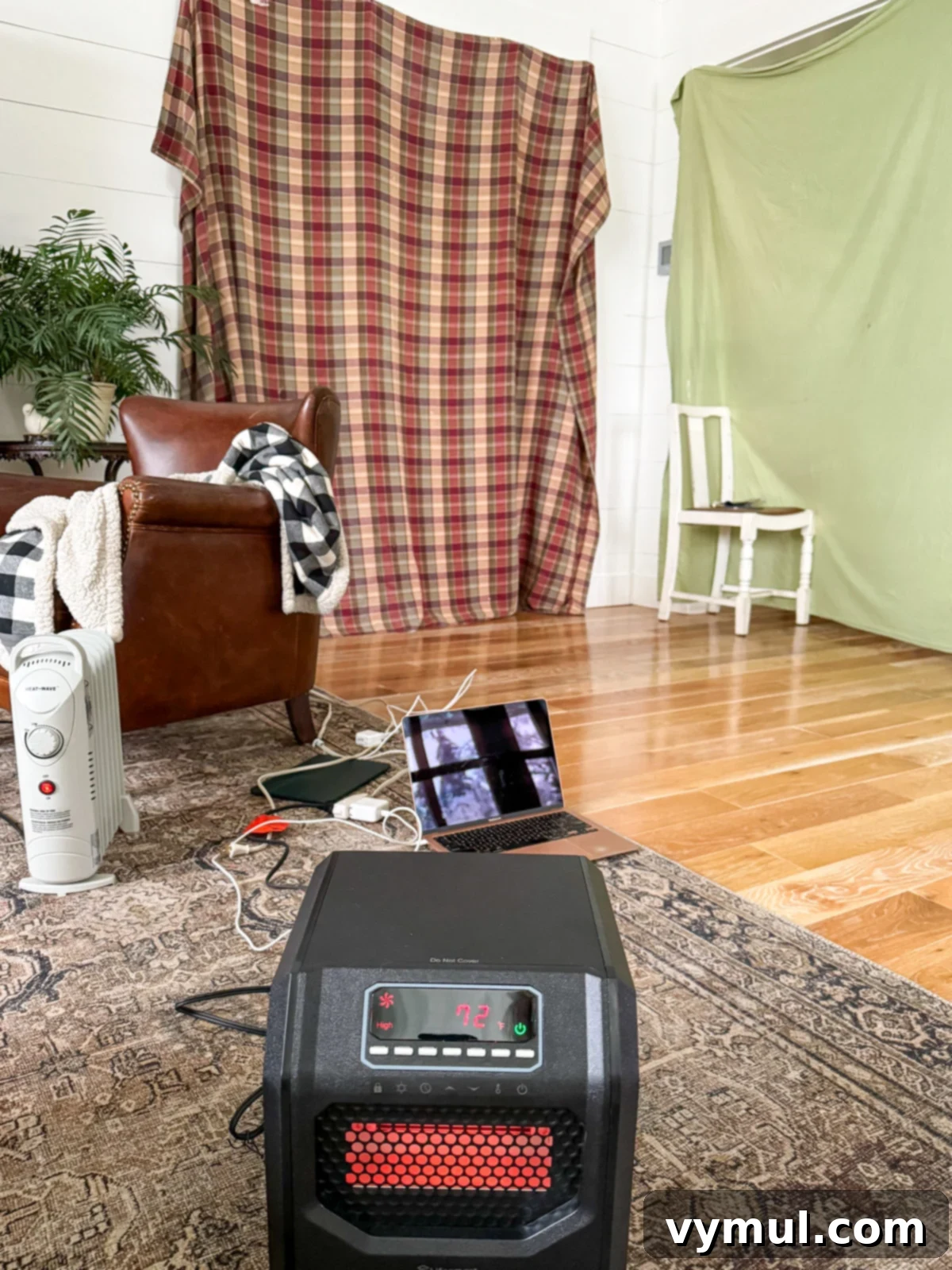 portable heater and old flannel sheets covering openings in living room