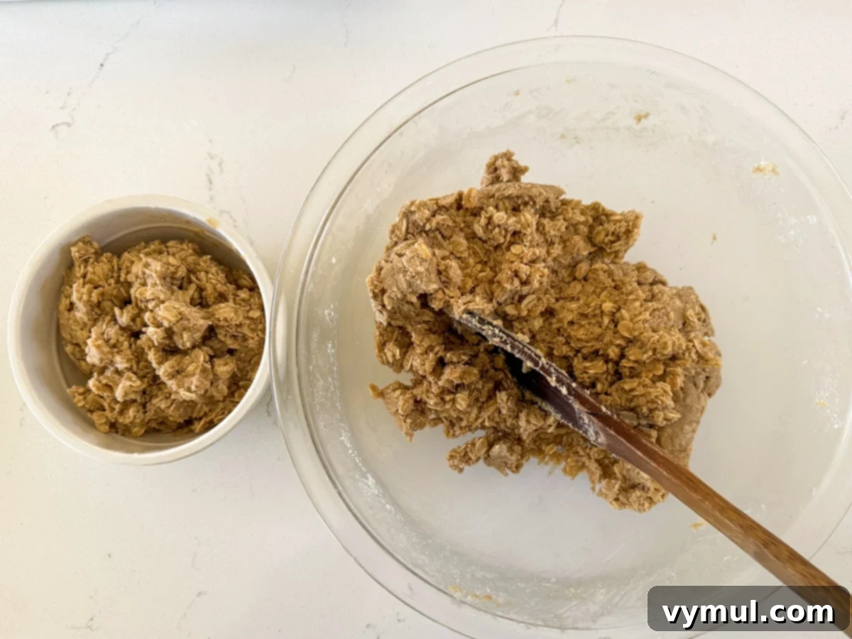 Step 2: A portion of the crumbly oat mixture is separated into a smaller bowl to be used as a topping later.