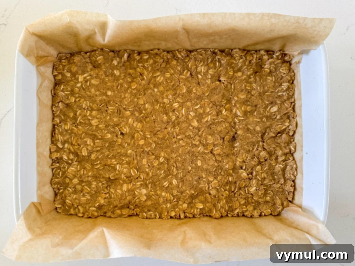Step 3: The remaining oat mixture is pressed into a baking pan and ready for pre-baking.