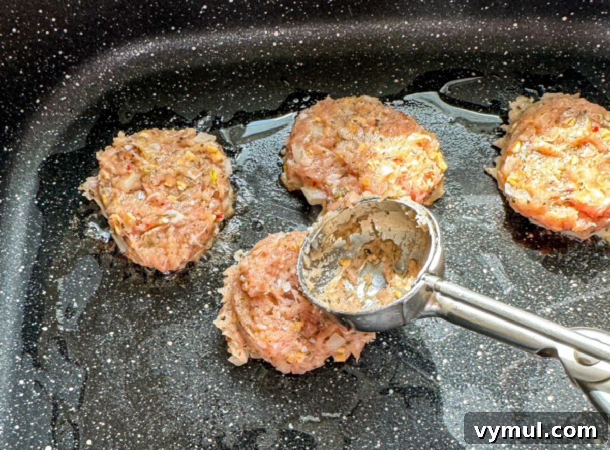 Speedy Wholesome Turkey Patties for Busy Mornings 5 Step-by-step image showing turkey patty mixture being scooped and flattened onto a hot skillet.