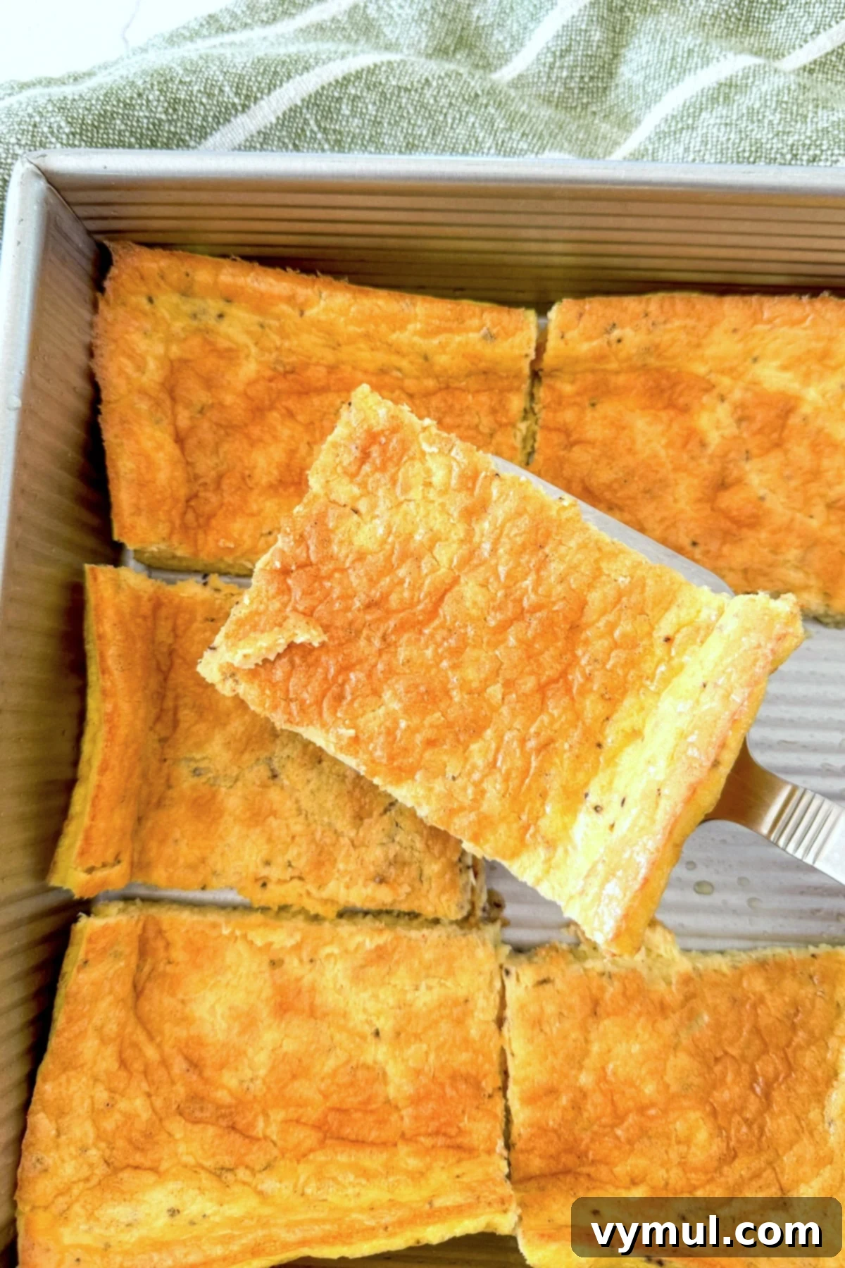 Protein-Packed Make-Ahead Cottage Cheese Eggs 2 A slice of high protein eggs ready to be served, showcasing its fluffy texture and golden-brown edges.