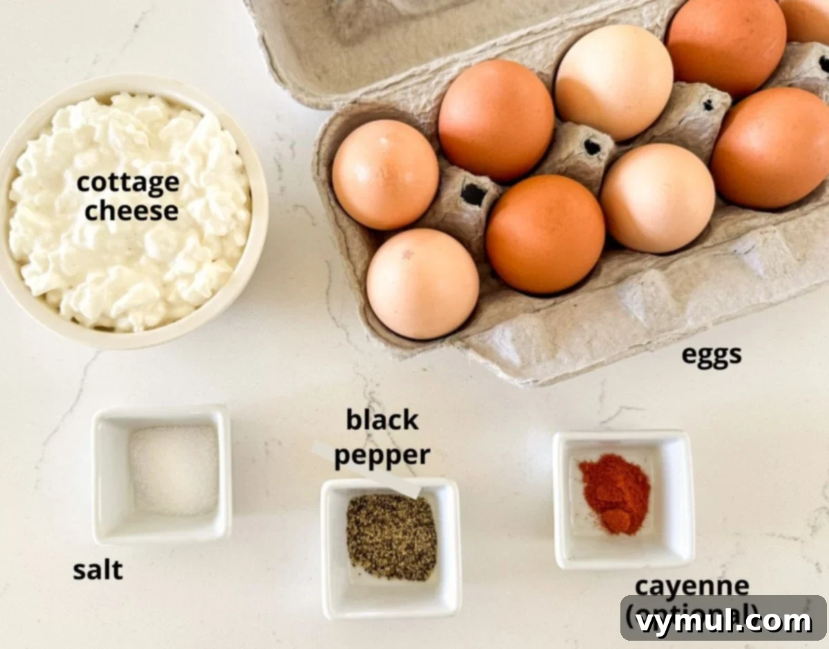Protein-Packed Make-Ahead Cottage Cheese Eggs 3 Various ingredients for high protein eggs laid out on a marble counter, including eggs, cottage cheese, salt, and pepper.