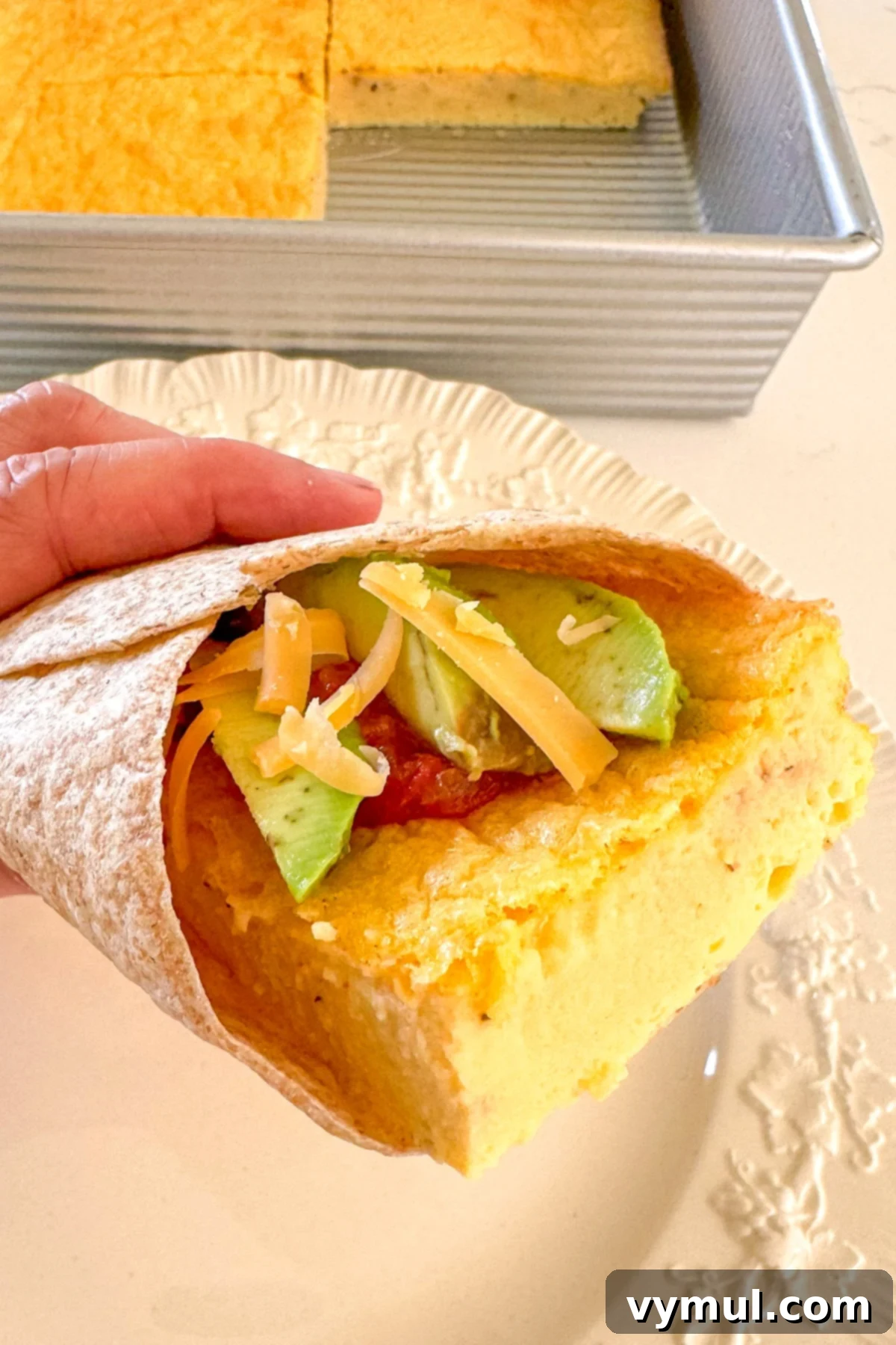 Protein-Packed Make-Ahead Cottage Cheese Eggs 9 High protein eggs served in a tortilla with melted cheese and fresh avocado slices, ready as a breakfast wrap.