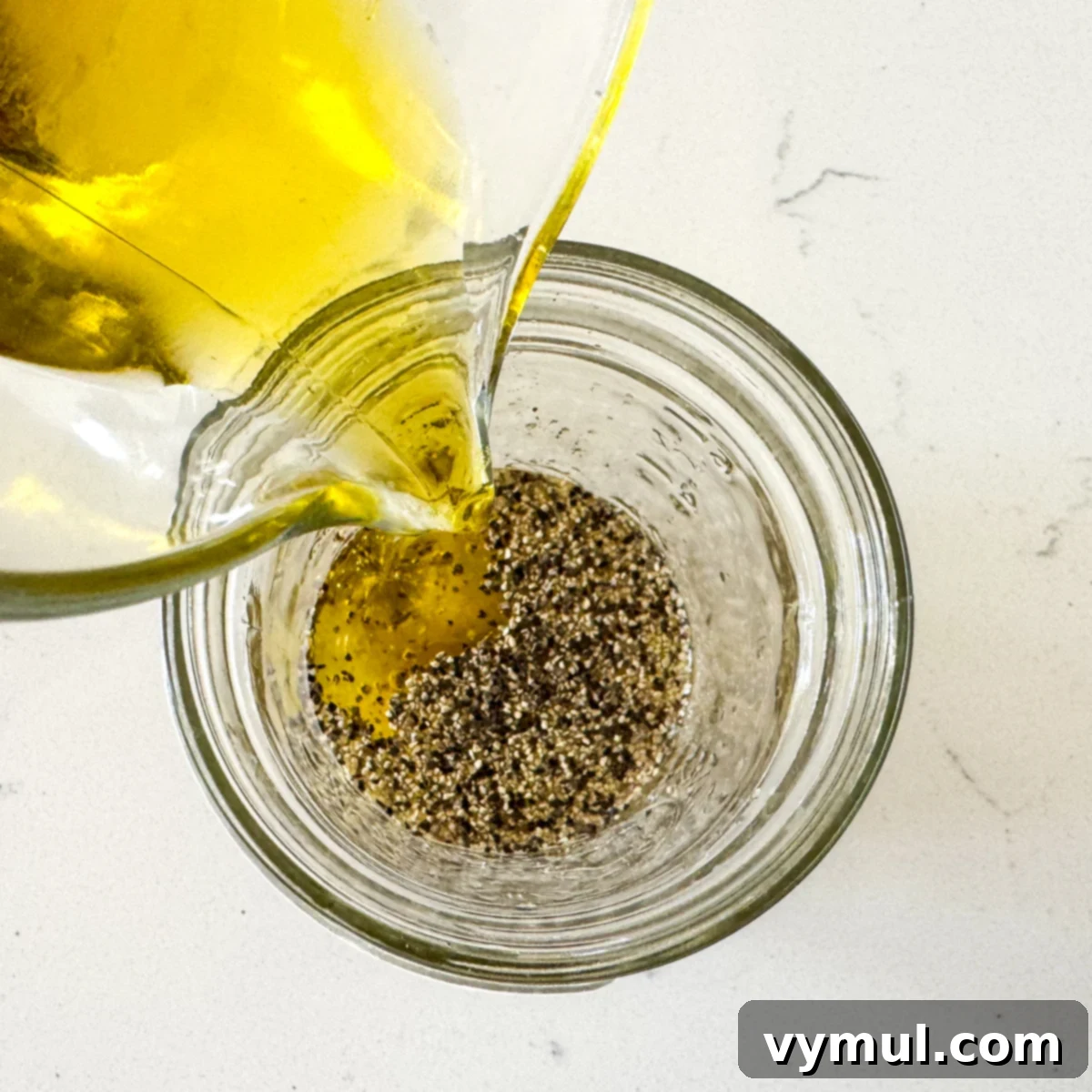 Zesty Lemon and Parmesan Kale Quinoa Salad 4 A glass jar with ingredients for lemon garlic dressing being whisked.