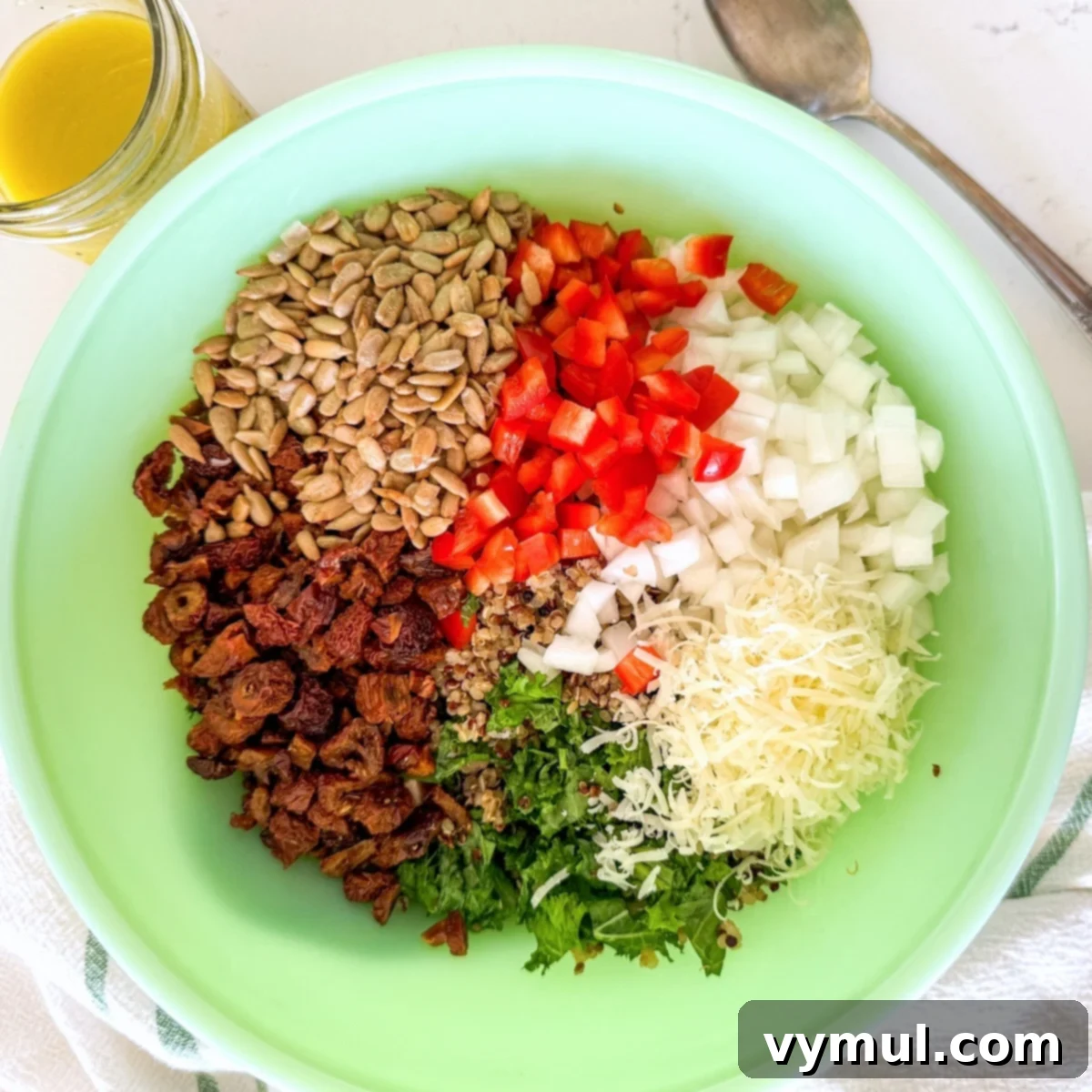 Zesty Lemon and Parmesan Kale Quinoa Salad 7 Various salad ingredients including kale, quinoa, and vegetables in a large mixing bowl.