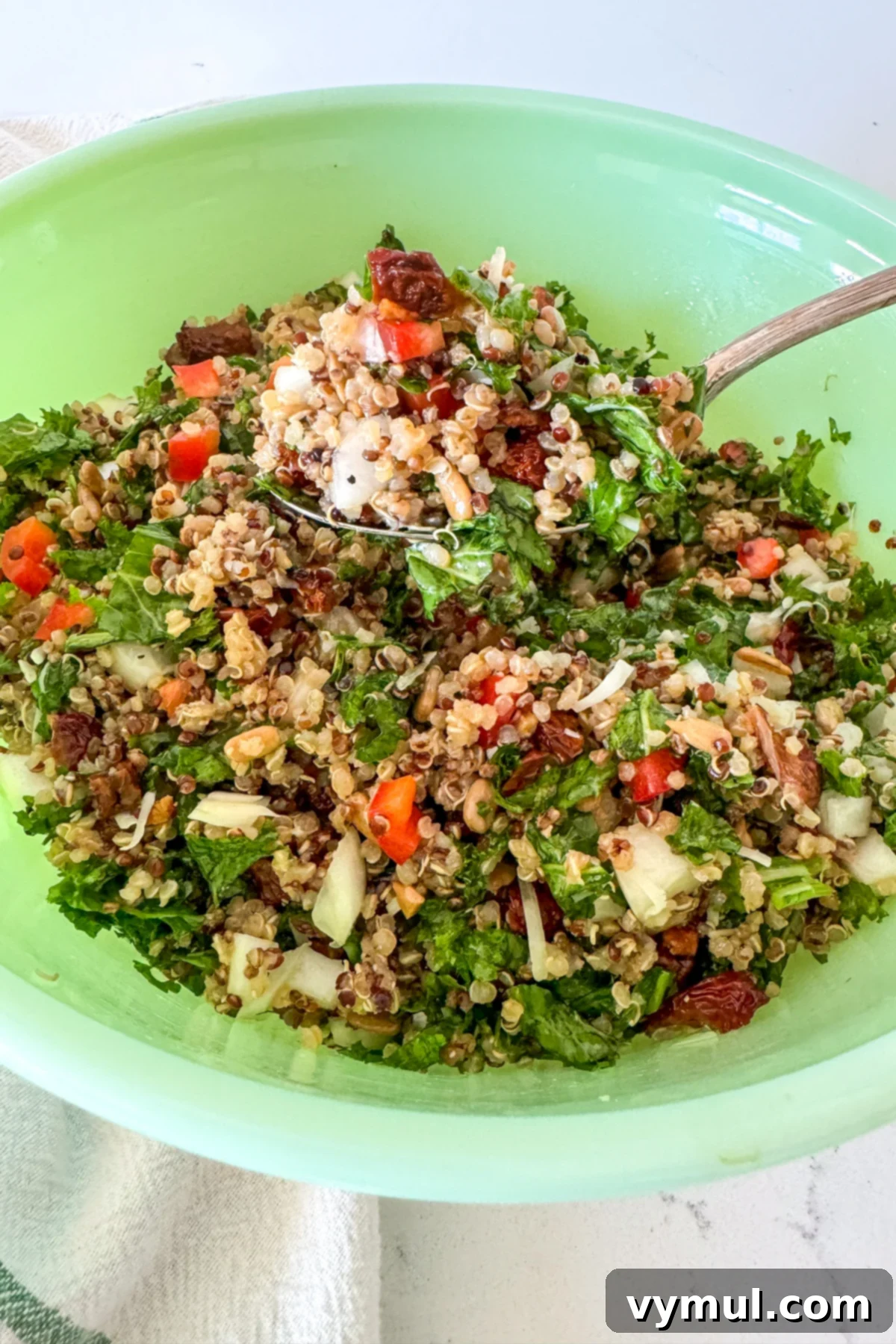 Zesty Lemon and Parmesan Kale Quinoa Salad 8 Close-up of mixed kale quinoa salad on a serving spoon.