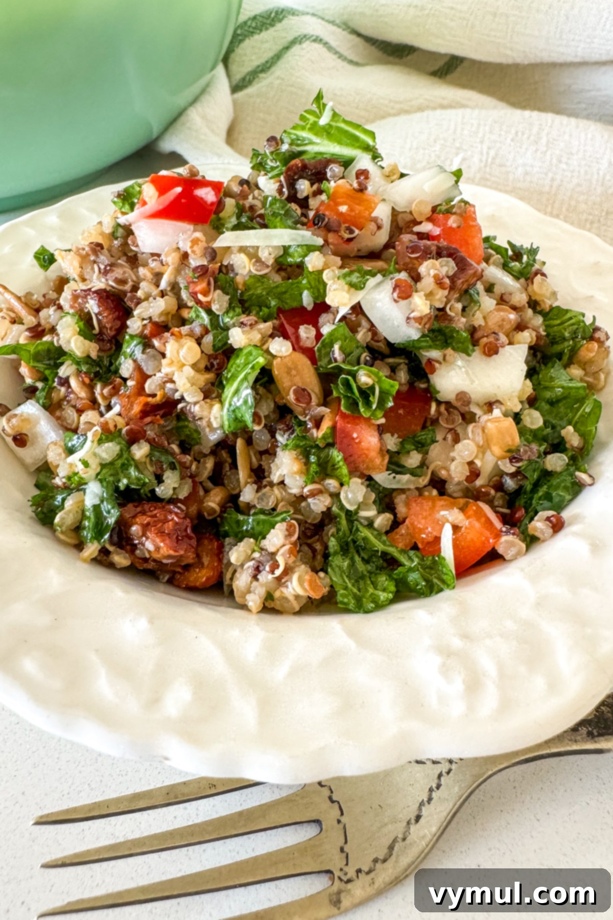Zesty Lemon and Parmesan Kale Quinoa Salad 9 Small white bowl overflowing with colorful kale quinoa salad.