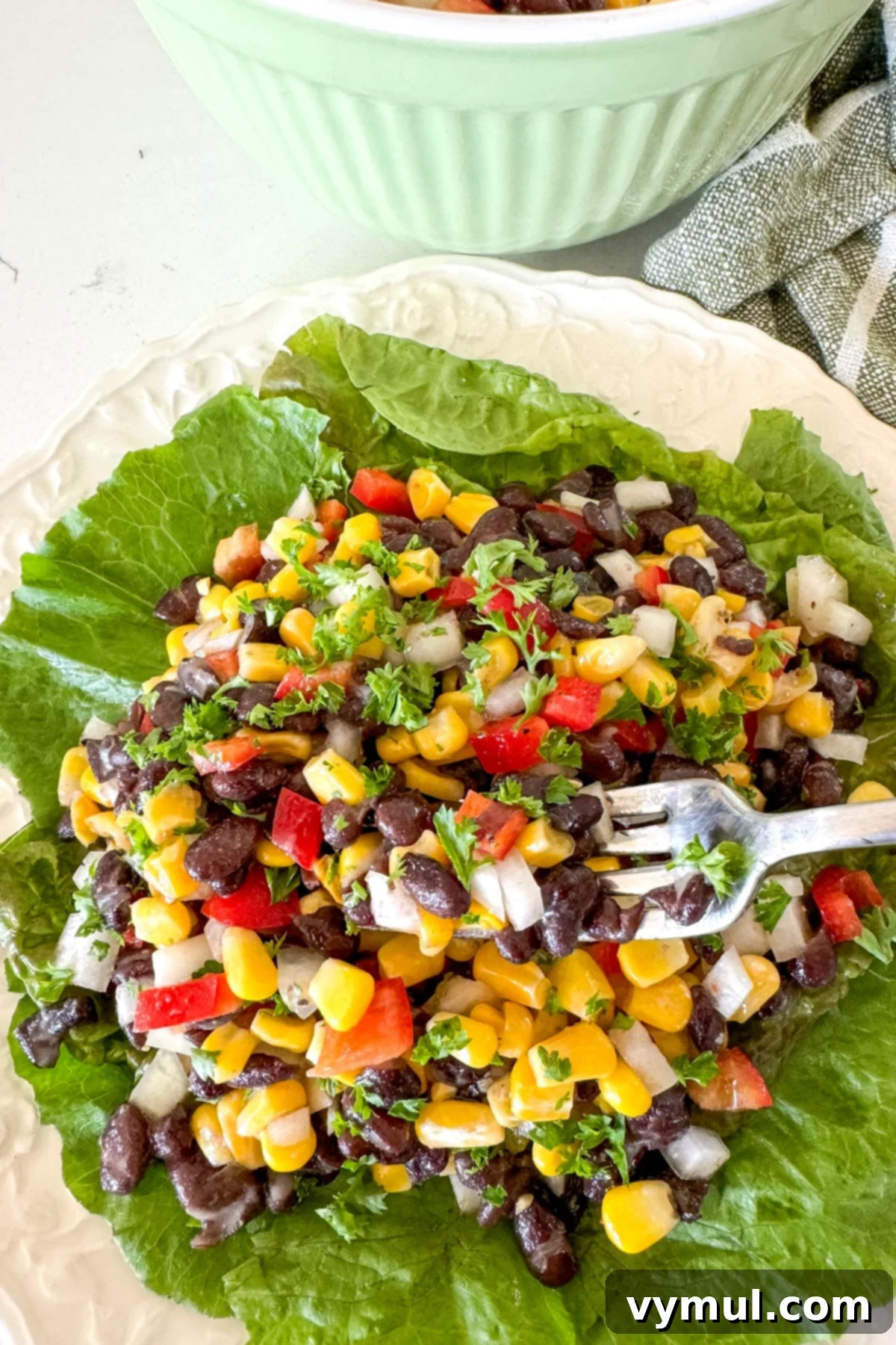 Zesty 10 Minute Black Bean and Corn Salad 2 black bean salad on a bed of lettuce with fork
