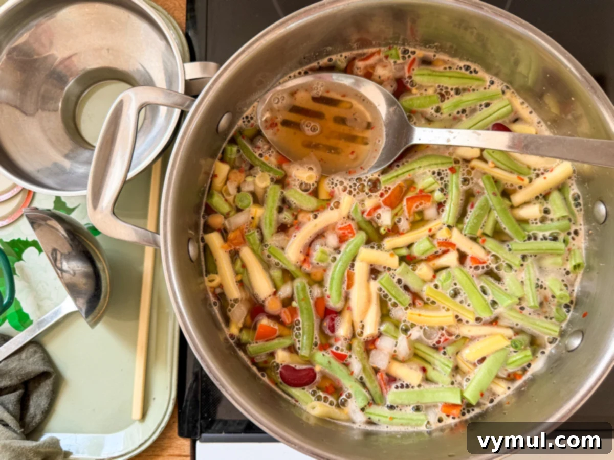 Cooked three bean salad in a large stockpot, ready to be transferred into canning jars.