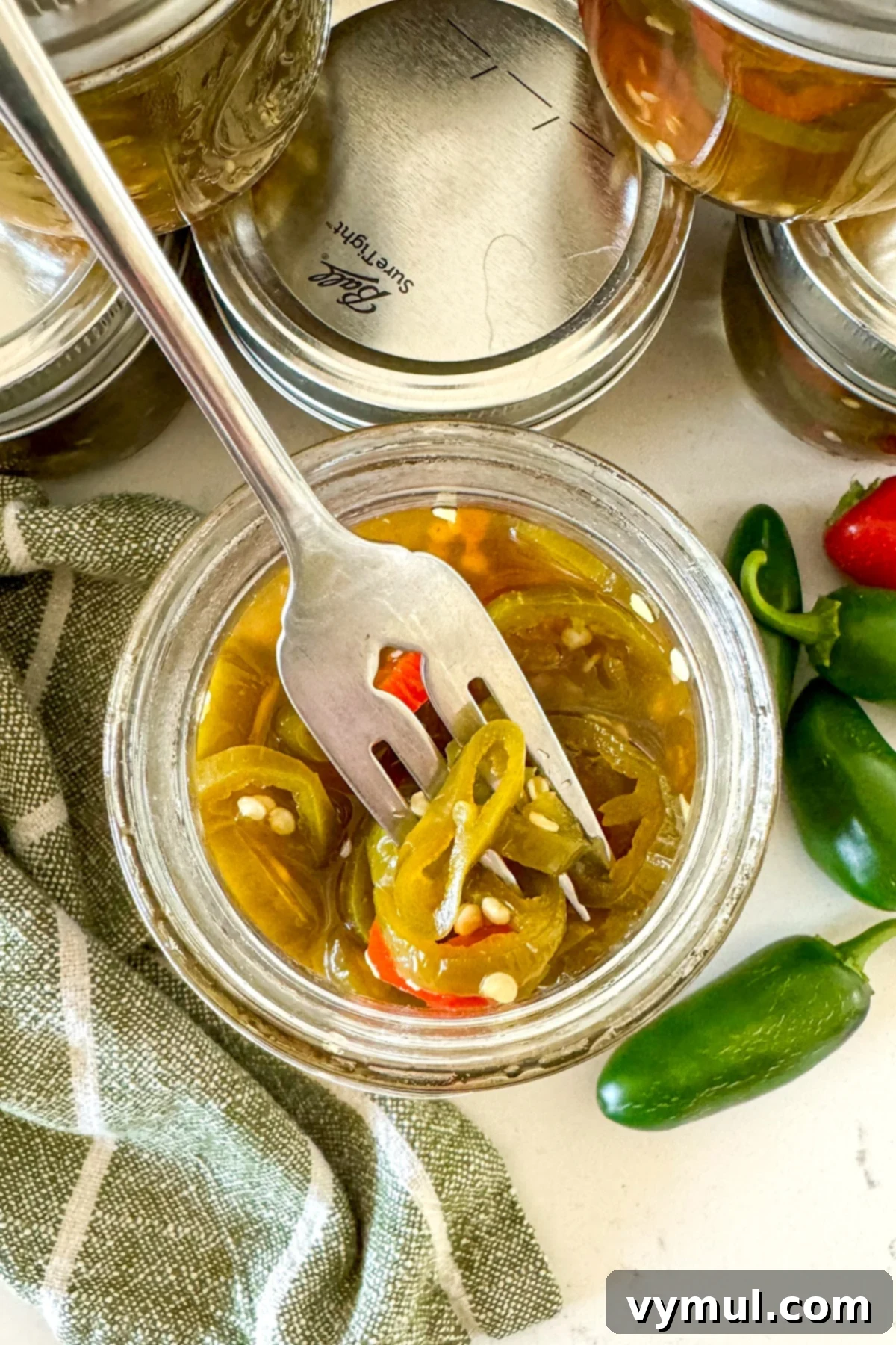 Sweet and Spicy Lower Sugar Cowboy Candy for Easy Canning 2 jar of cowboy candy jalapeños in jar with fork