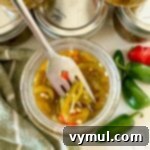 Sweet and Spicy Lower Sugar Cowboy Candy for Easy Canning 11 cowboy candy peppers in jar with fork