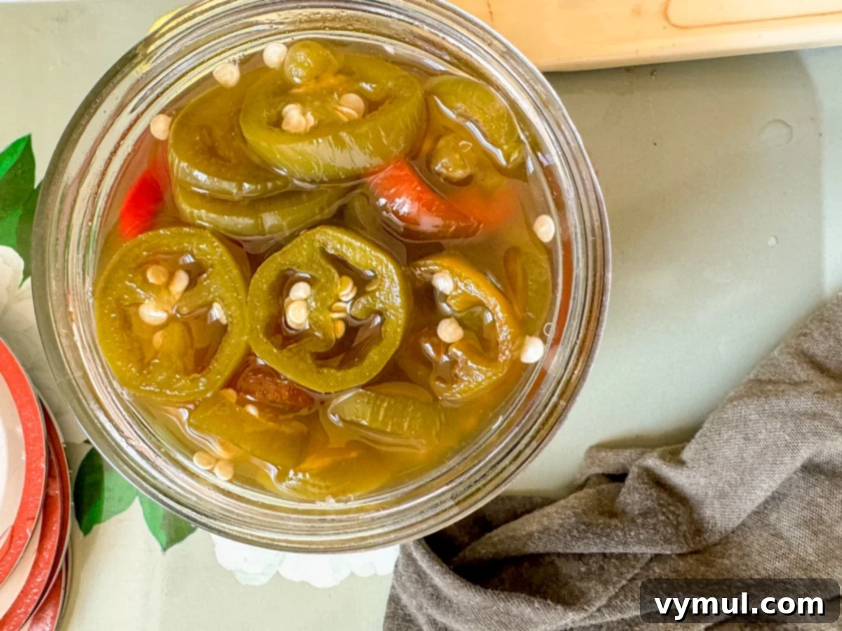 Sweet and Spicy Lower Sugar Cowboy Candy for Easy Canning 7 candied jalapeños in canning jar