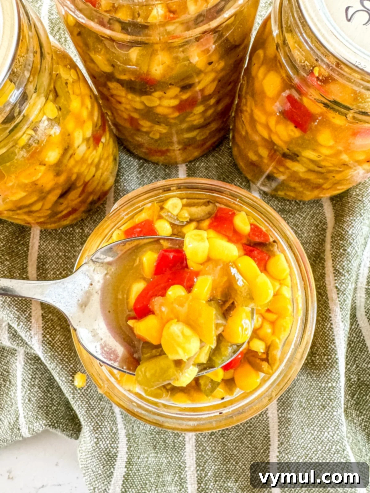 Spicy Olive Corn Relish: Water Bath Canning 4 spoon in open jar of corn relish from above