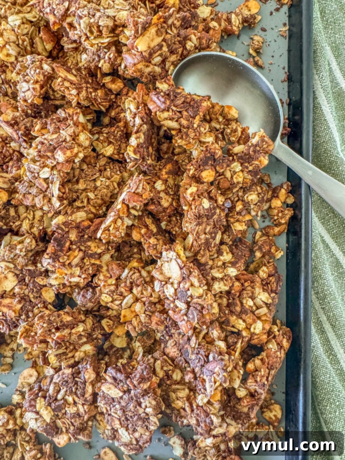 Freshly baked maple cinnamon protein granola broken into clusters on a baking sheet, ready for serving.