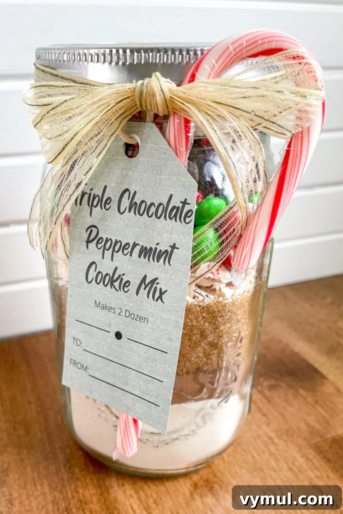 Triple Chocolate Peppermint Cookie Jar Mix with Printable Tags 2 A beautifully layered jar of triple chocolate peppermint cookie mix, adorned with a festive tag and ribbon, perfect for a holiday gift.
