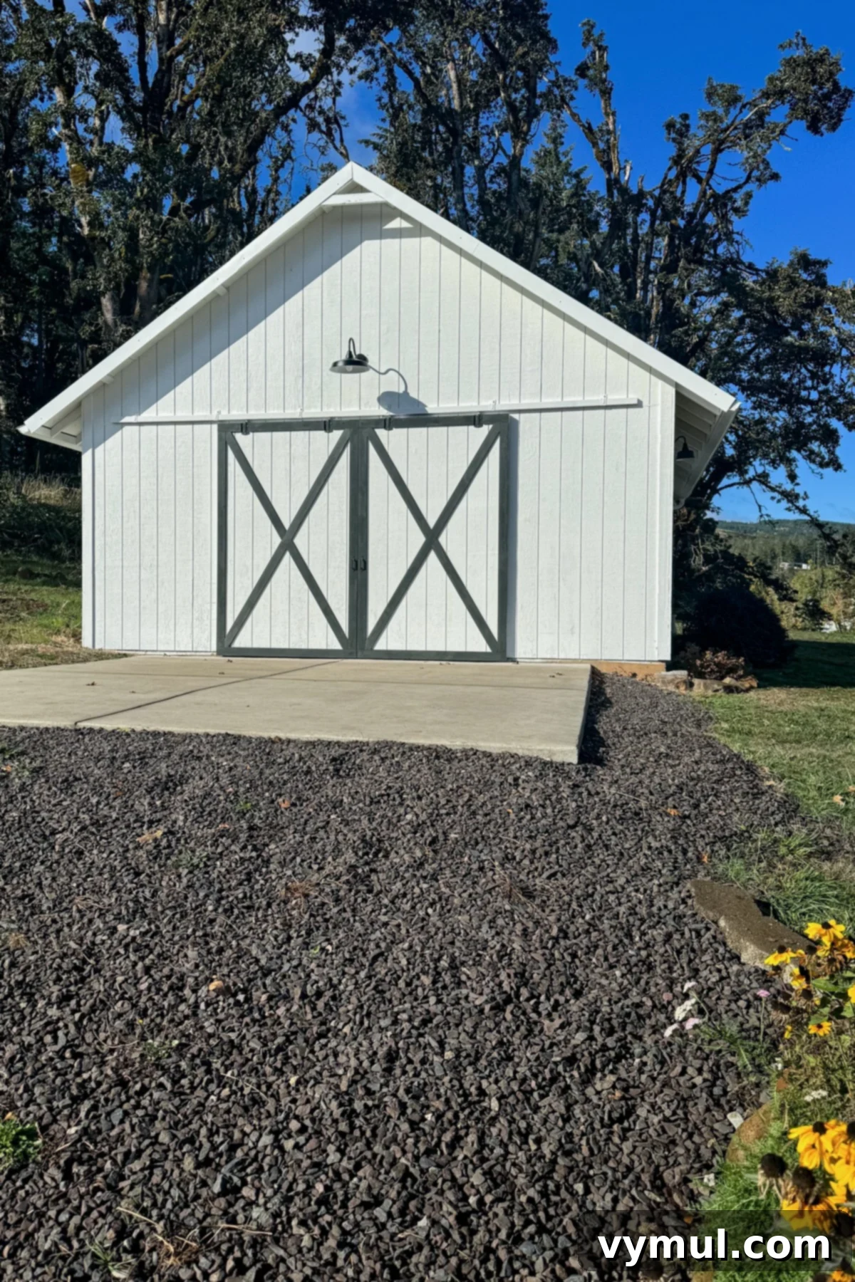 Effortless Barn Exterior Update 2 white barn with green 'X' molding on the doors